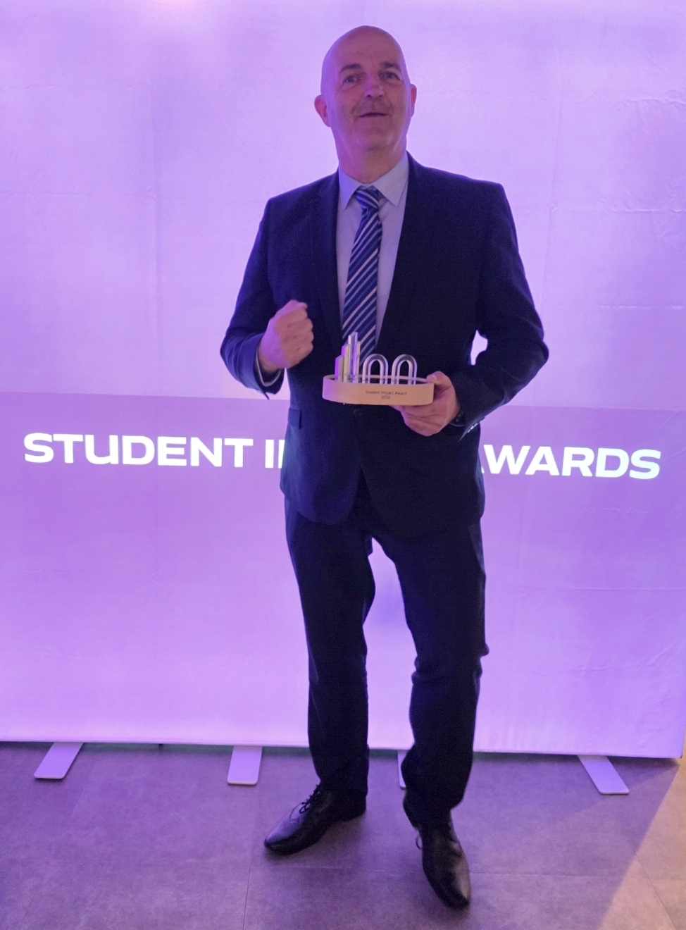 John Ryder holding an impact award